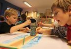 Dzieci malujące farbami przy wspólnym stole
