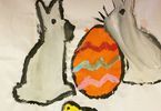 Praca na tkaninie przedstawiająca dwa zające, jajko i żółtego kurczaka
