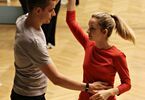 Dziewczyna w czerwonej bluzce i chłopak podczas obrotu w tańcu