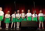 Zdjęcie grupowe; dziewczynki na scenie w zielonych spódnicach i białych koszulkach