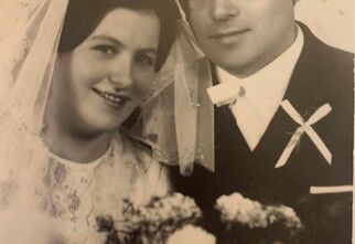 Czarno-biała fotografia zdjęcia weselnego z młodą parą i bukietem kwiatów